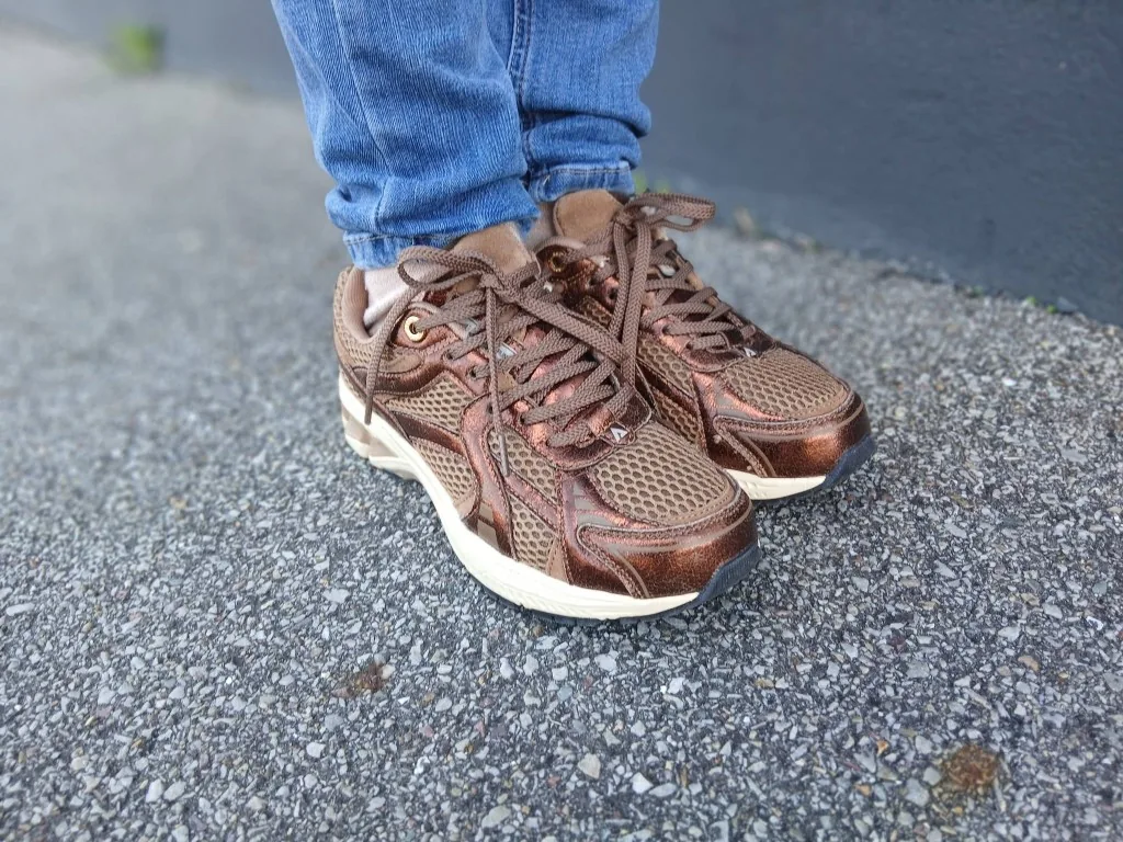 Baskets bronze en mesh et cuir, portées sur le bitume